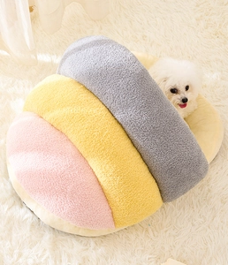 Detail view of colorful plush cat bed with soft cloud velvet fabric and a white dog inside