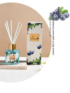 Close-up of blueberry reed diffuser set with glass bottle and fiber sticks in white box
