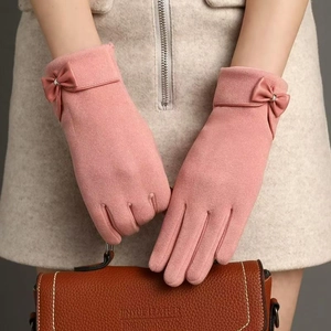 Detail of pink faux suede winter gloves with bow decor and touch screen fingertips