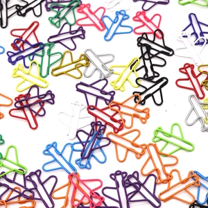 Colorful airplane shaped metal paper clips in assorted colors on a clean white background