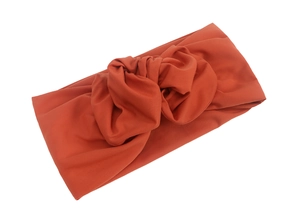 Detailansicht des ziegelroten geknoteten Turban-Stirnbandes aus hochwertigem Baumwollstrick