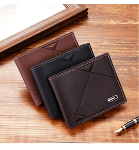 Detailed view of three leather wallets in black and brown on a wooden desk with a pen