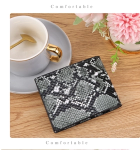 Close-up of vintage faux snakeskin leather wallet with bifold design on wooden surface