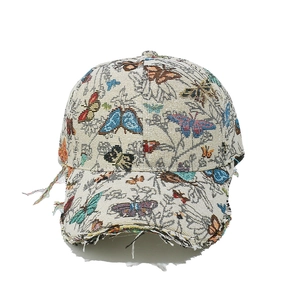 Detailed close-up of colorful butterfly jacquard embroidery and frayed edge of baseball cap