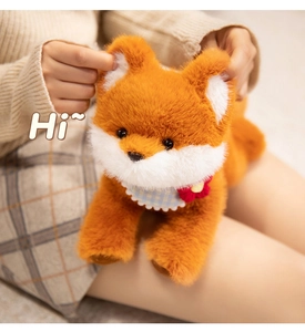 Close-up of cute plush fox toy with blue plaid bib and floral detail in hand
