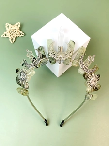 Detail of green raw stones and silver moon celestial accessories on bohemian crown