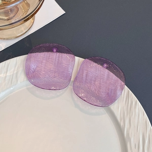 Translucent purple acrylic square earrings with hammer texture on a white plate