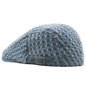 Detail of light blue denim ivy cap featuring distressed textures and vintage metal buckle