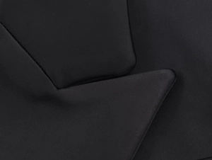 Dettaglio del rever a lancia di un blazer nero satinato con trama di tessuto raffinata
