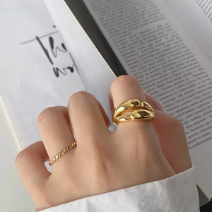 Close-up of dual-layer gold-plated rings in organic and twisted rope minimalist styles