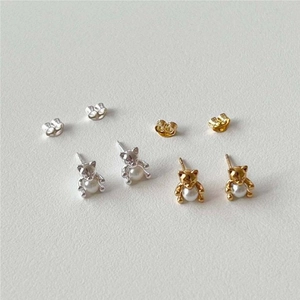 Close-up of bear-shaped 925 silver earrings with pearls in gold and silver finishes