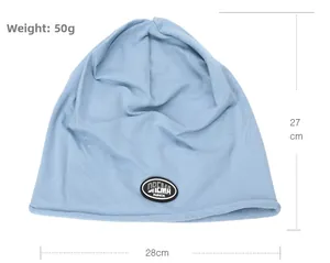 Close-up of light blue knitted beanie with circular black logo patch and rolled edge