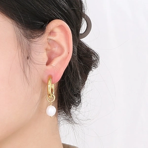 Gros plan détaillé d'une boucle d'oreille vintage en perles sur un modèle fini en or