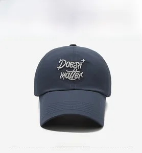 Detail of navy blue baseball cap featuring white 3D embroidered Doesn't matter text