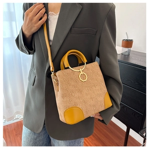 Detail of monogram print tote bag with metal handle ring and adjustable strap on a model