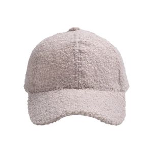 Close-up of the plush teddy fleece texture and stitching on a warm beige baseball cap