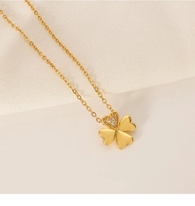 Detail of clover necklace showing gold leaves and heart petal with sparkling crystals