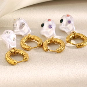 Macro shot of 18K gold hammered hoops with colorful rhinestone baroque pearl charms