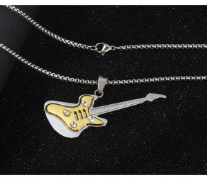 Macro shot of silver guitar necklace with gold front plate and three sparkling rhinestones