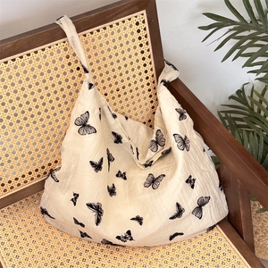 Lace butterfly print canvas tote bag detailed view on a vintage wooden chair
