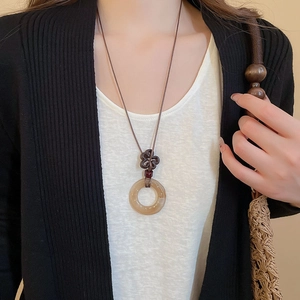 Close-up of vintage resin pendant necklace with traditional knot on elegant female model