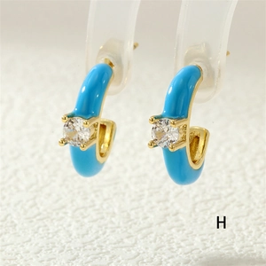 Macro shot of sky blue C-shape earrings with gold plating and sparkling zircon stones
