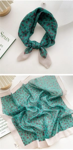Detail of green floral cotton linen scarf with soft red flowers and ivory textured edges