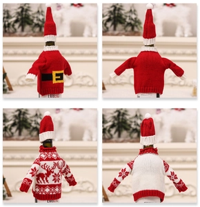 Detail view of knitted reindeer Christmas wine bottle cover with mini sweater and hat decor