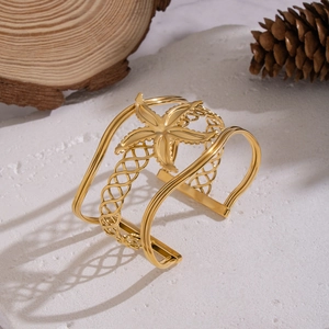 Wide hollow gold plated stainless steel cuff bracelet with a 3D starfish element