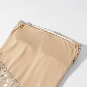 Gros plan détaillé de la doublure abricot et des coutures de paillettes sur la robe de soirée
