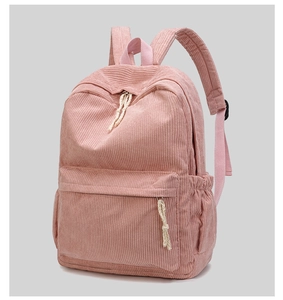 Close-up of pink corduroy backpack with white braided zipper pulls and side pockets