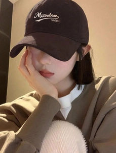 Close-up of white Mizoobeau embroidery on a dark grey vintage cotton baseball cap