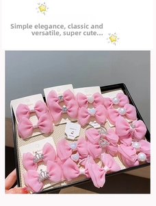 Detail of pink chiffon bow hair clips with pearls and crown on a white display card