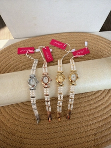 Close-up of pearl bracelet watches with oval mother-of-pearl dials in four metal colors