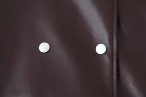 Close-up of deep brown PU leather jacket featuring silver metal buttons and stitching