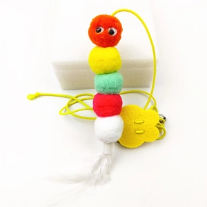 Close-up of plush cat teaser toy with colorful fuzzy balls, feathers, and elastic string