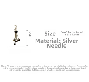 Detail view of 925 silver needle vintage earrings with tiger eye bead and long metal tassels