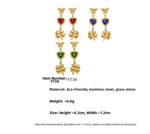 Detail of three pairs of stainless steel butterfly drop earrings with colored glass hearts