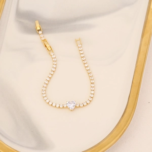 18K gold plated zircon bracelet with heart pendant and pavé stones on marble tray