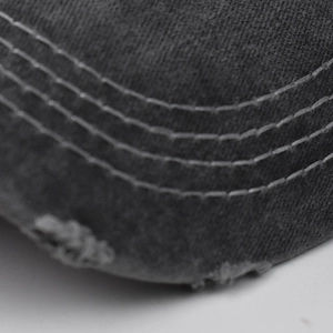 Macro detail of distressed brim on washed cotton baseball cap with five-row stitching