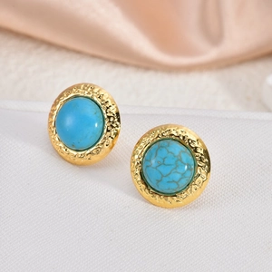Detail of 18K gold-plated earrings with turquoise stone and hammered metal texture