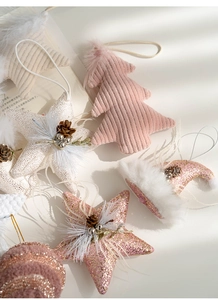 Detailed view of pink and white plush Christmas ornaments with stars and mini trees