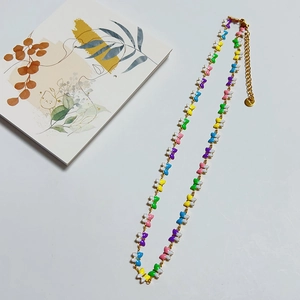 Detailed close-up of a colorful butterfly charm necklace with a golden extension chain
