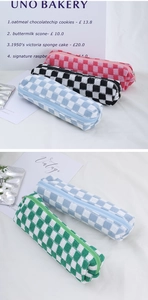 Detail of checkered knit pencil pouches in pink, black, blue, and green with metal zippers