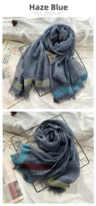 Detail of haze blue thin wool scarf featuring frayed edges and vintage colored stripes