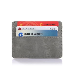 Detailed view of gray matte PU leather card holder with three vertical slots and fine stitching