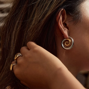 Luxe gold and silver spiral pearl earrings and matching wrap ring set on a model