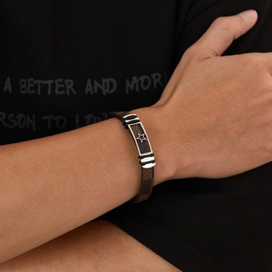 Close-up of men's brown leather punk bracelet with stainless steel star detail on wrist