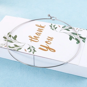 Detail of silver stainless steel choker with a spherical hook clasp on a gift card