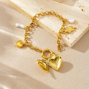 Gold-plated heart locket bracelet with pearls and floral charms on natural stone